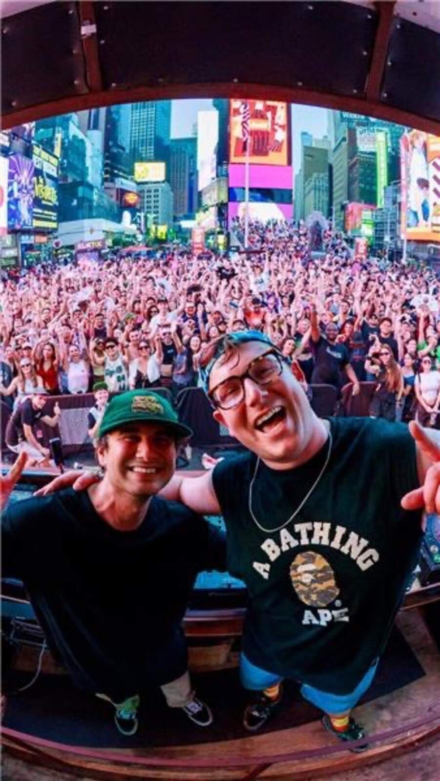 DJs selfie from the bus with massive Times Square crowd behind