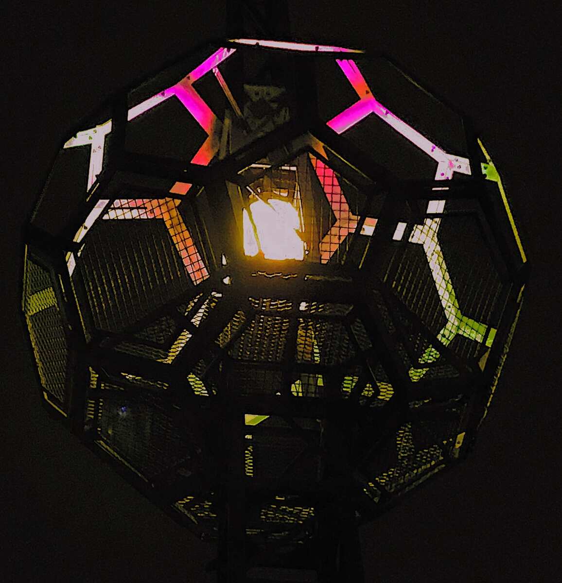 Looking up into the buckyball interior — steel frame and lit panels