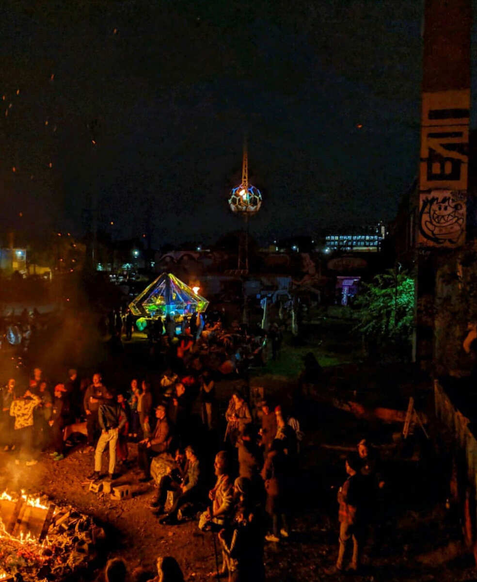 Crowd gathered around fires below the beacon