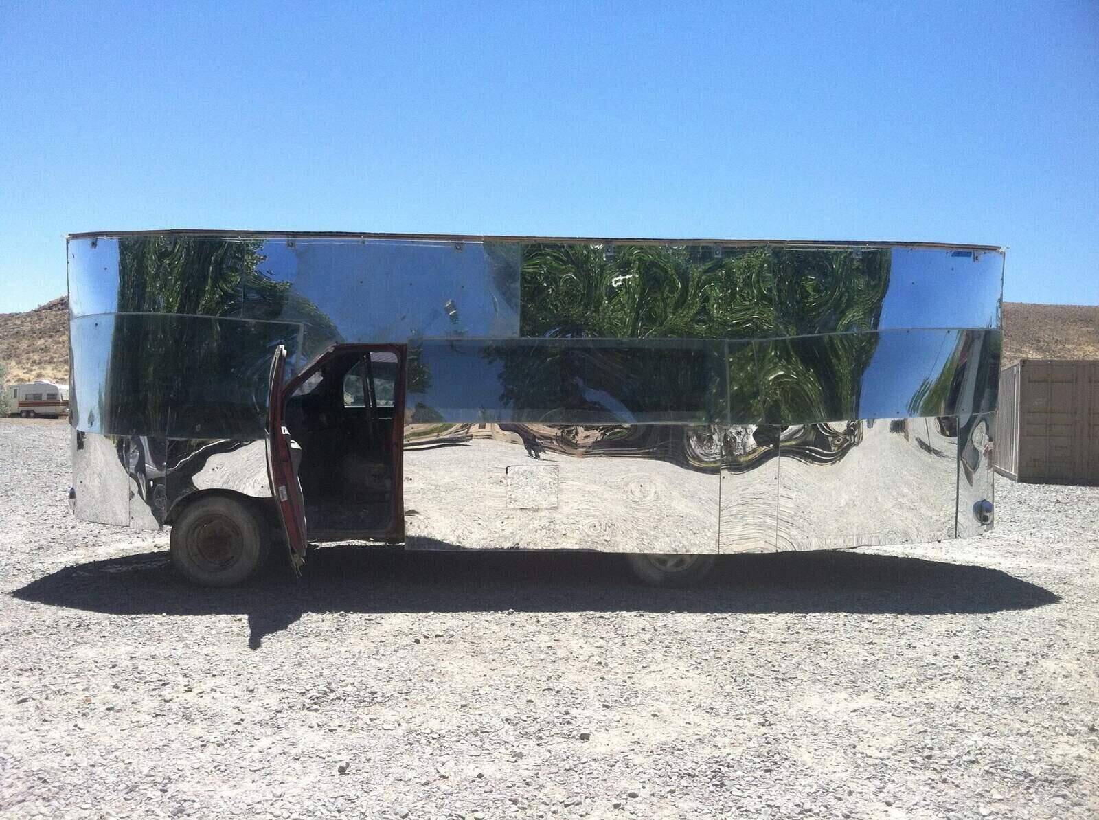 Full side view — the van reflects the desert floor and distant mountains