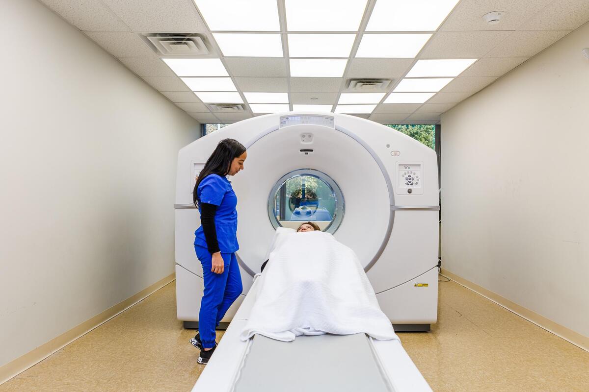 PET/CT scan room — technician with patient entering the scanner